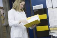 Female scientist looking at a MSDS binder