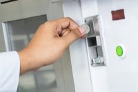 Close-up of human hand inserting coin in vending machine