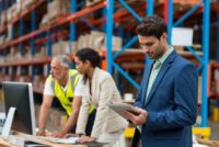 Warehouse managers and worker working together in warehouse office